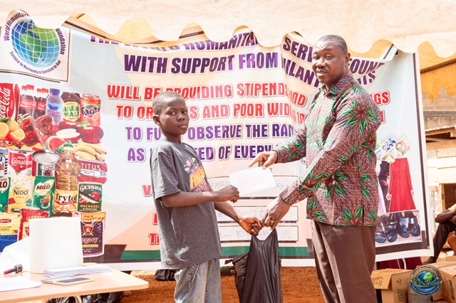 Young orphan receiving a stipend envelope